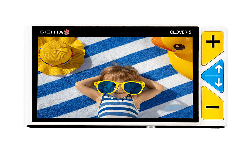 Digital camera display showing a child with sunglasses and a hat on a blue and white striped background. Clover 5 Special Needs Computers.