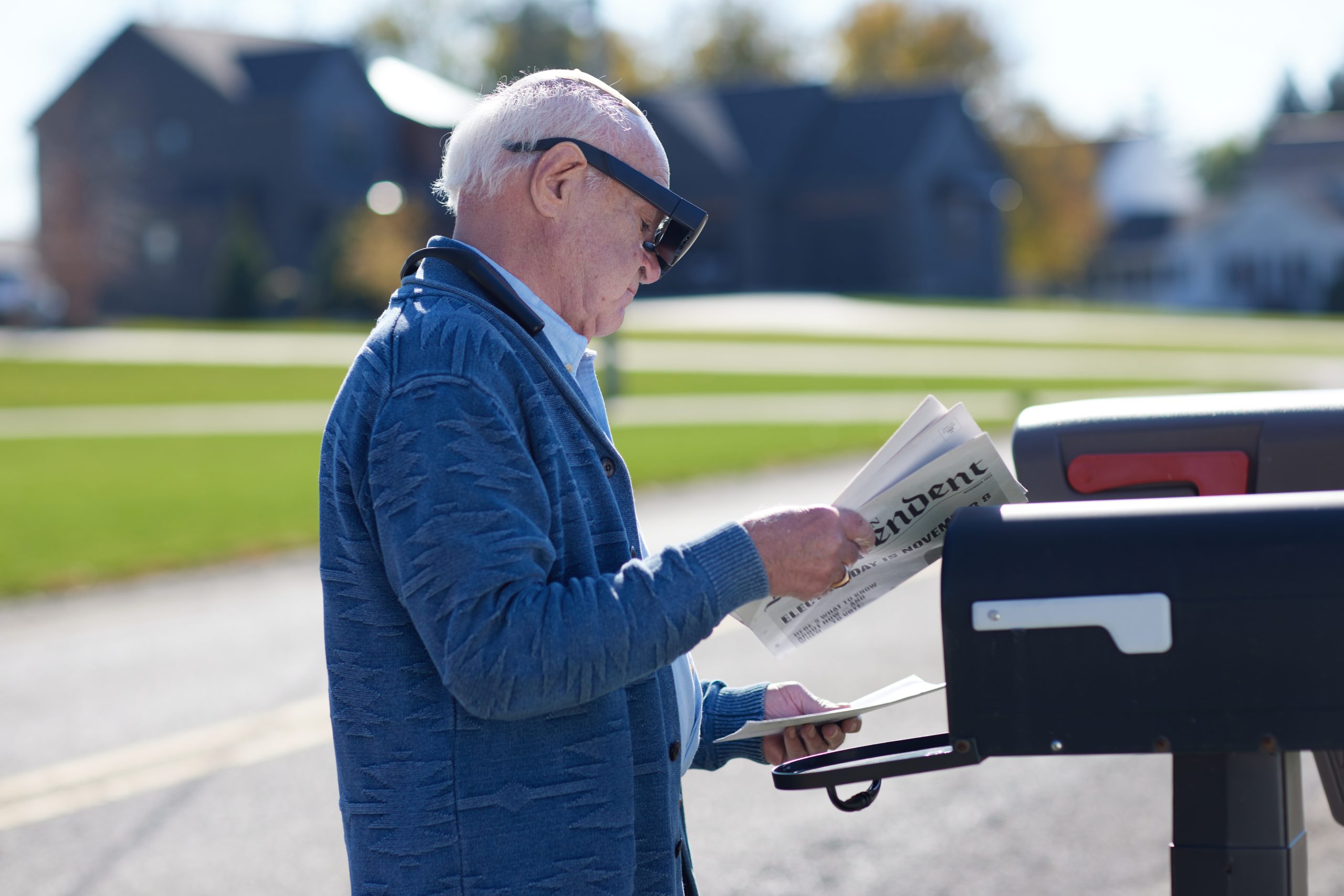 man at mailbox reading 
