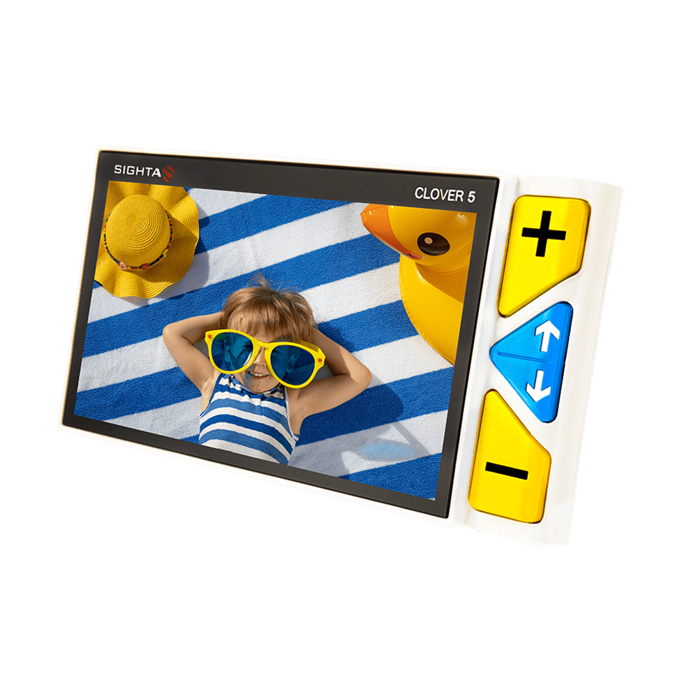 A SIGHTA Clover 5 digital video monitor with a white casing and yellow control buttons, shown on a solid green background. The screen displays a child wearing yellow sunglasses on a blue and white striped blanket. Clover 5 Special Needs Computers.