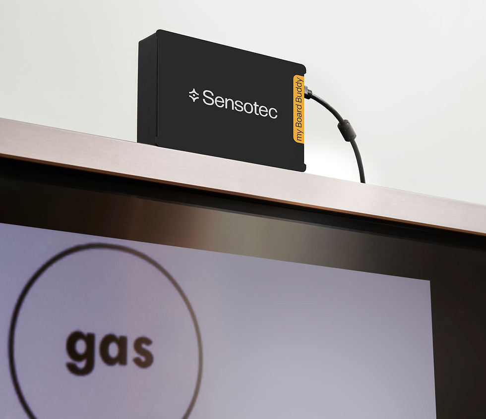 A Sensotec myHomeSensor3 device in black with a yellow label, mounted on a metallic shelf above a screen displaying the word 'gas'.  Special Needs Computers