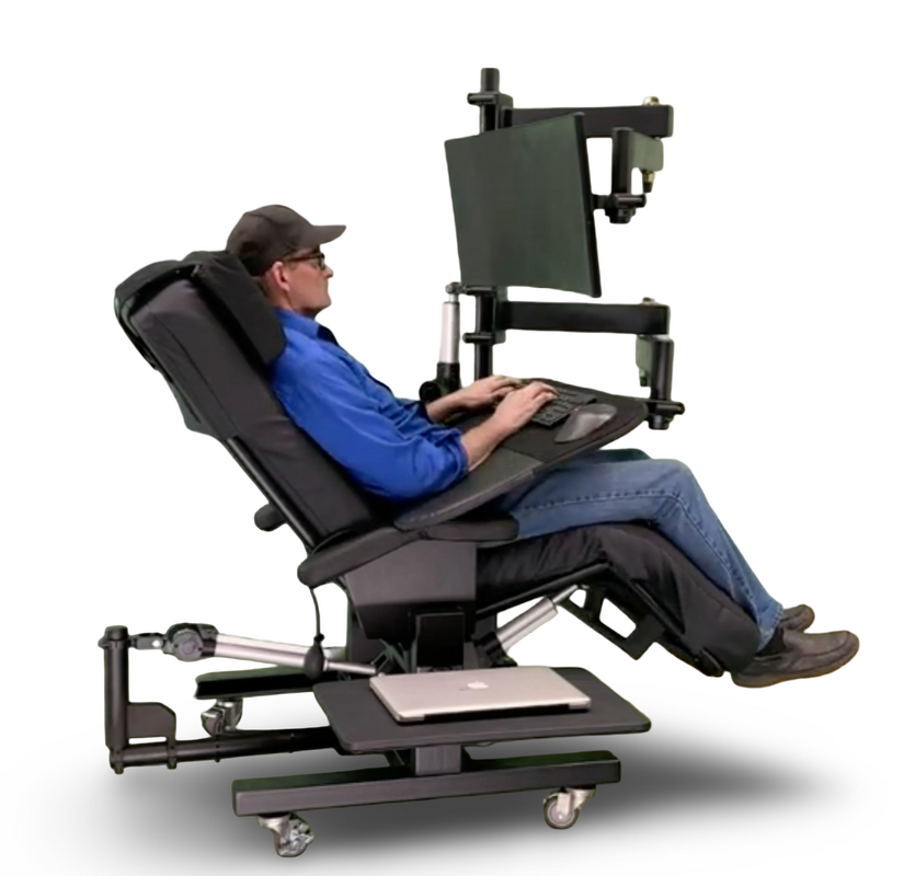 A person reclining in a black ergonomic computer workstation chair with an attached monitor, keyboard tray, and footrest, shown on a white studio background.  Zero Gravity Workstation 1c. Special Needs Computers Canada.